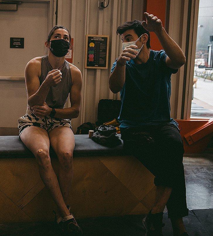 Josh coaching Kyra through visualizing different routes on the wall