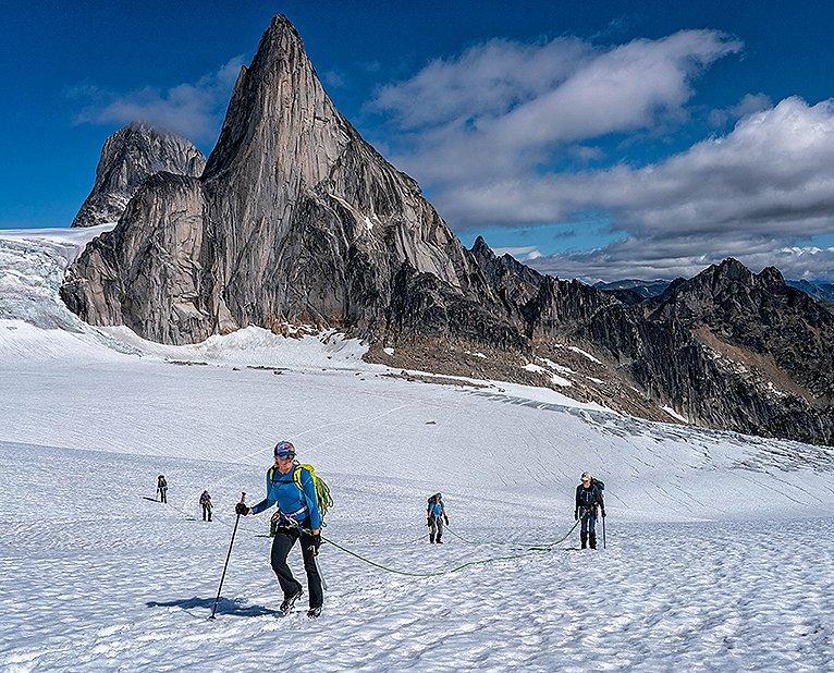 A group of AAC members smile at the camera while trekking up the snowy mountain