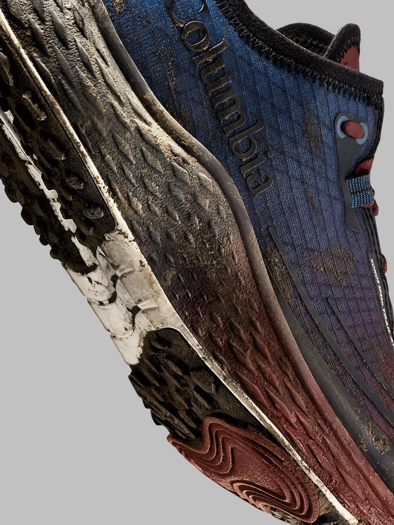 Close-up of athletic shoe sole showing textured rubber tread with dirt and wear marks.