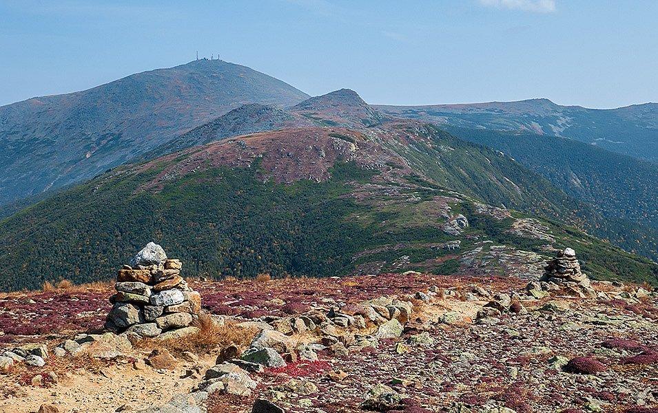 Large rock piles adorn the Appalachian Trail as it winds along the top of a hilly ridge.