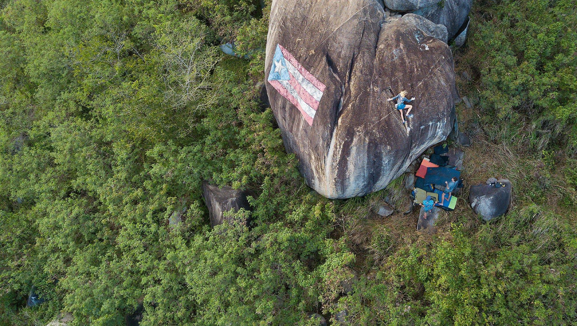Kyra bouldering in Puerto Rico; a Puerto Rico flag drawn on the rock.