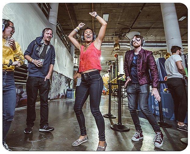 A group dances at the silent disco portion of the 2019 Woman Up event