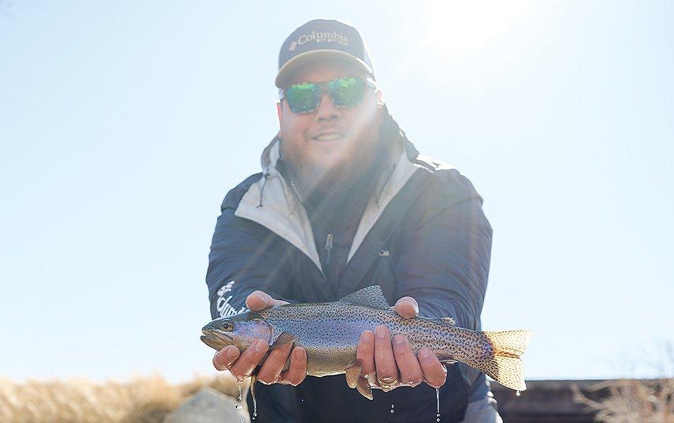 Luke Combs holding a trout. 