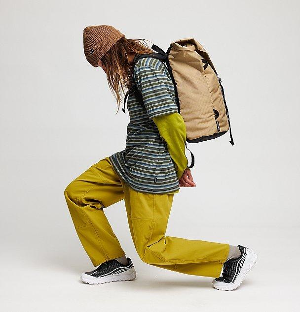 A vibey studio shot of a female climber bending forward in the Rockrydge pants.