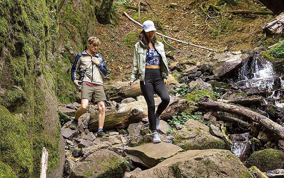 Man and woman hiking down rocky terrain 