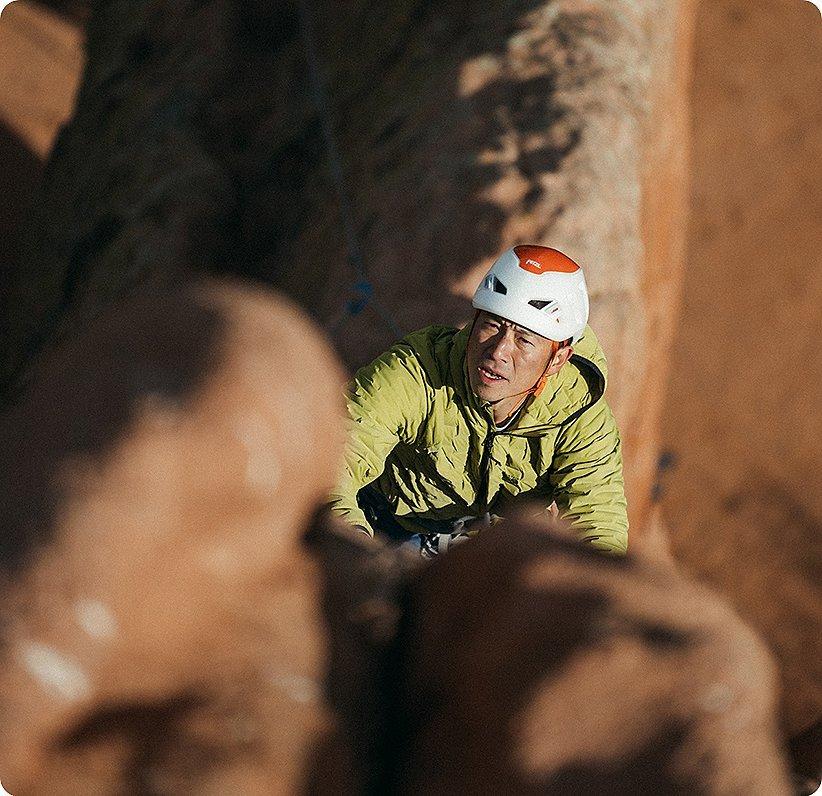 Cody in the light climbing up a rock face