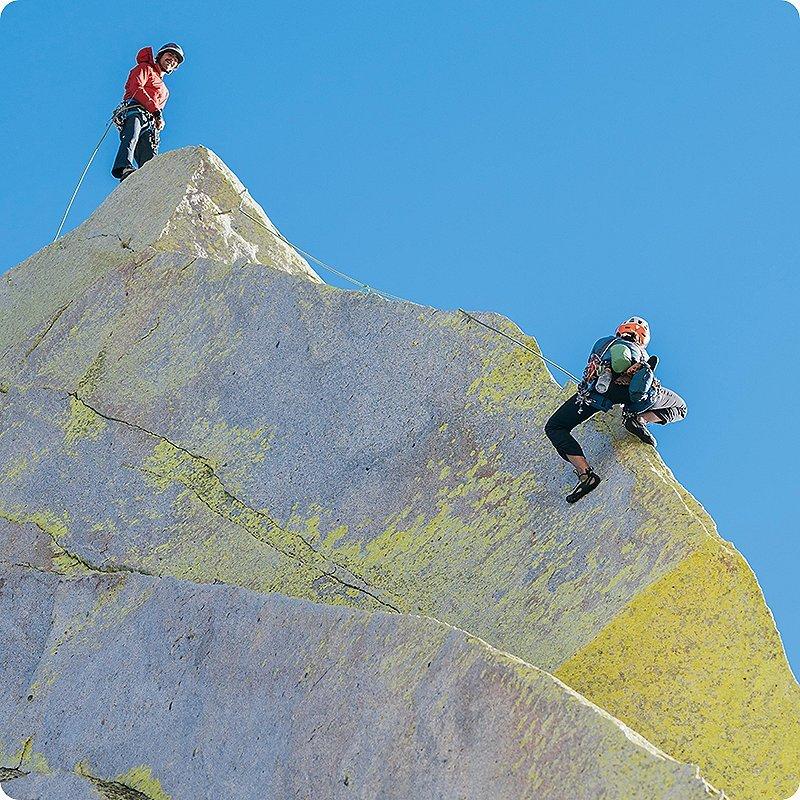 Two climbers in the sun at the top of their climb