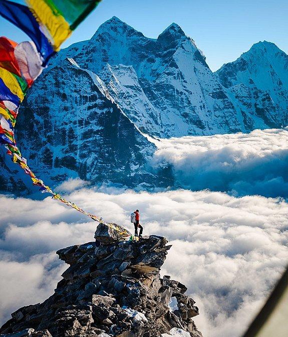 Mountaineering in Nepal, Garrett Madison takes in the view standing on a peak.