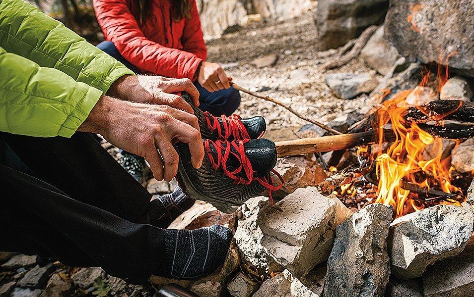 People around a campfire drying out shoes. 