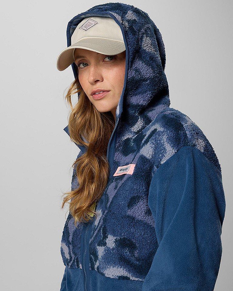 A woman in a cozy blue fleece with the hood up.