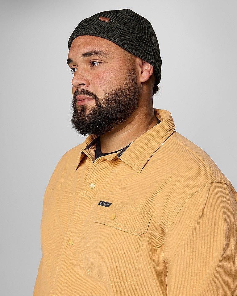A stylish guy in a yellow shirt jacket and beanie.
