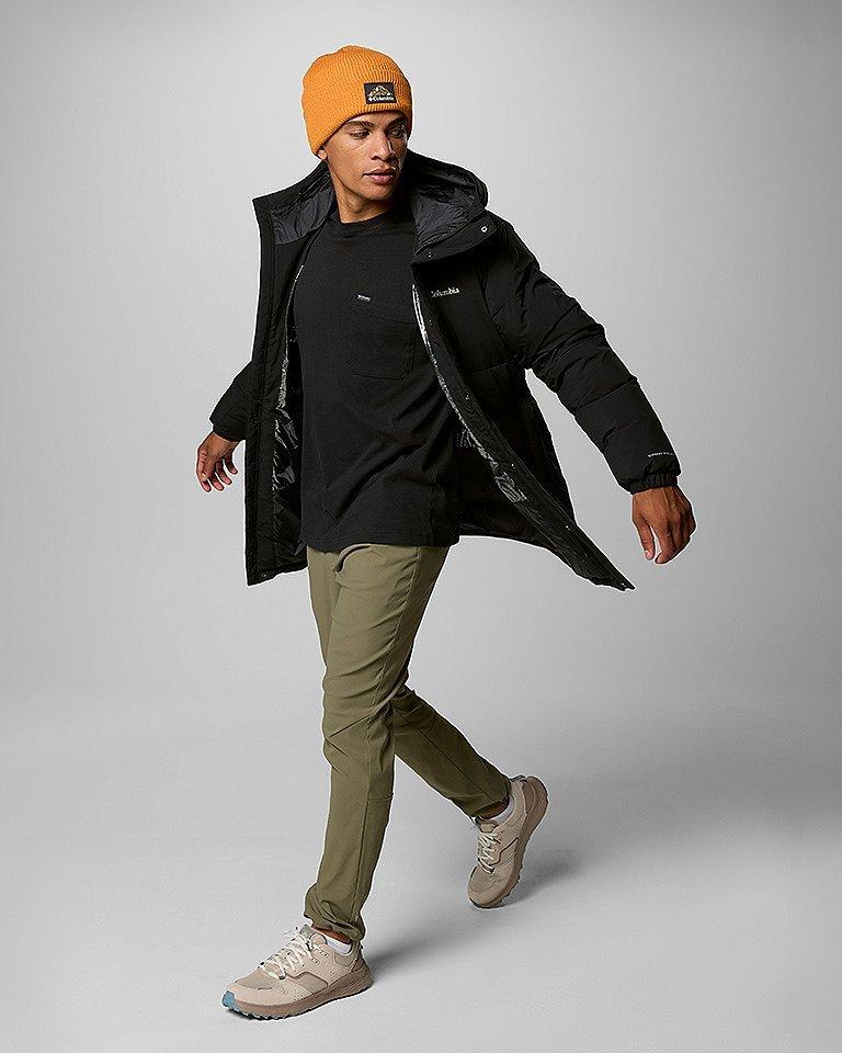 A man walking in an outdoor outfit.