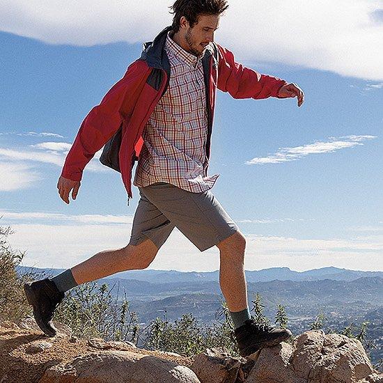 A man in Columbia hiking boots walking over rocks.  