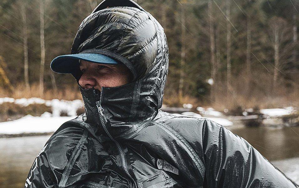 Pro angler Curtis Ciszek stands by a cold river in the wintertime wearing a Columbia Sportswear rain jacket. 