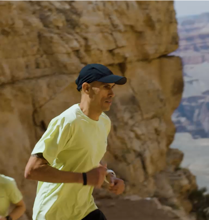 Man trail running in a desert landscape.