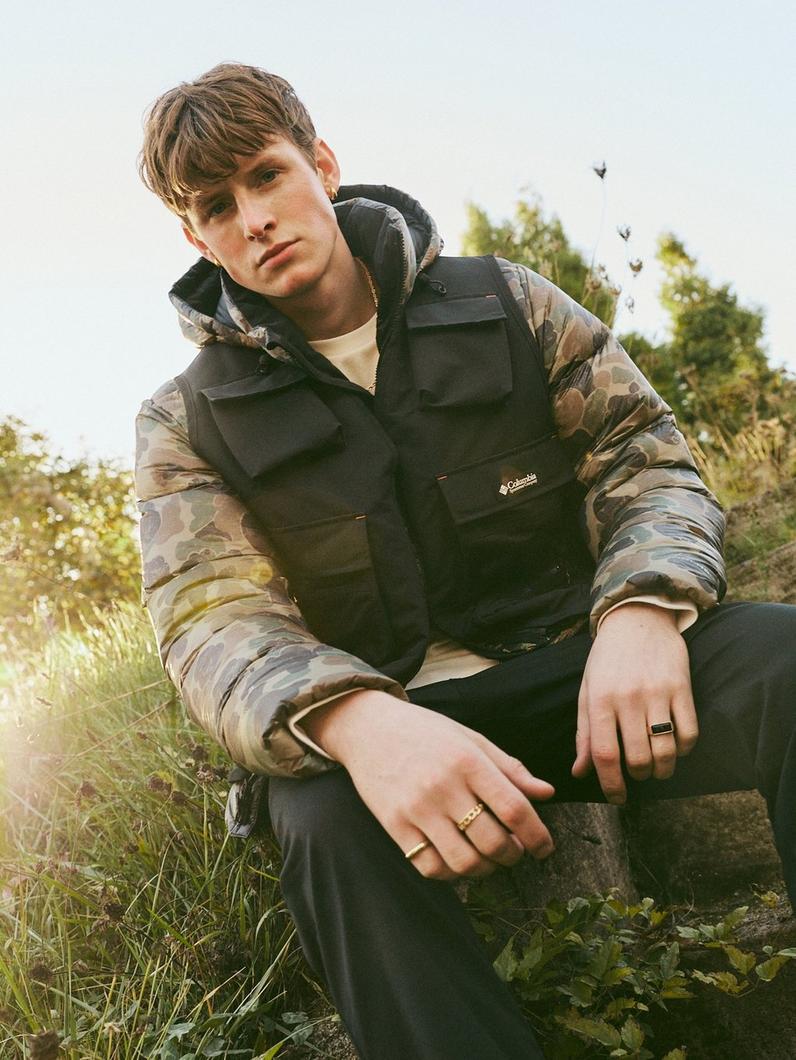 Man posing in CSC1938 gear outside in front of greenery.