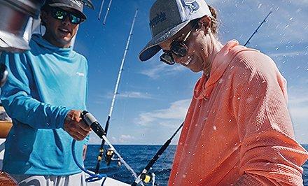 A man on a boat in a long-sleeve shirt with Omni-Shade Broad Spectrum technology. 