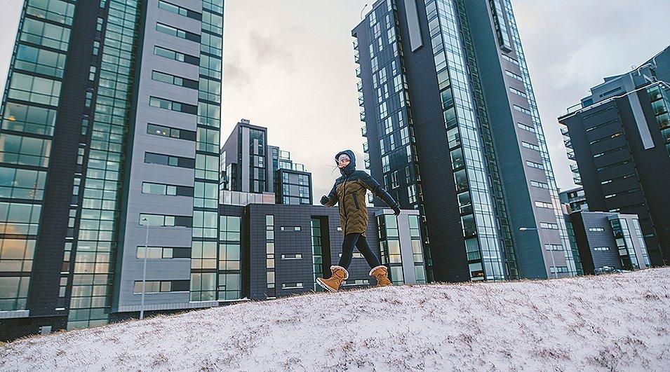 A woman walking through a snowy city in Columbia gear.