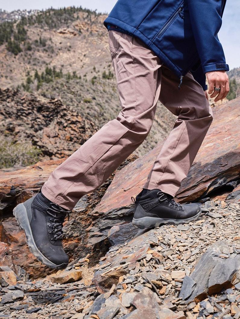 Hiker in ROC pants climbing up a mountain.