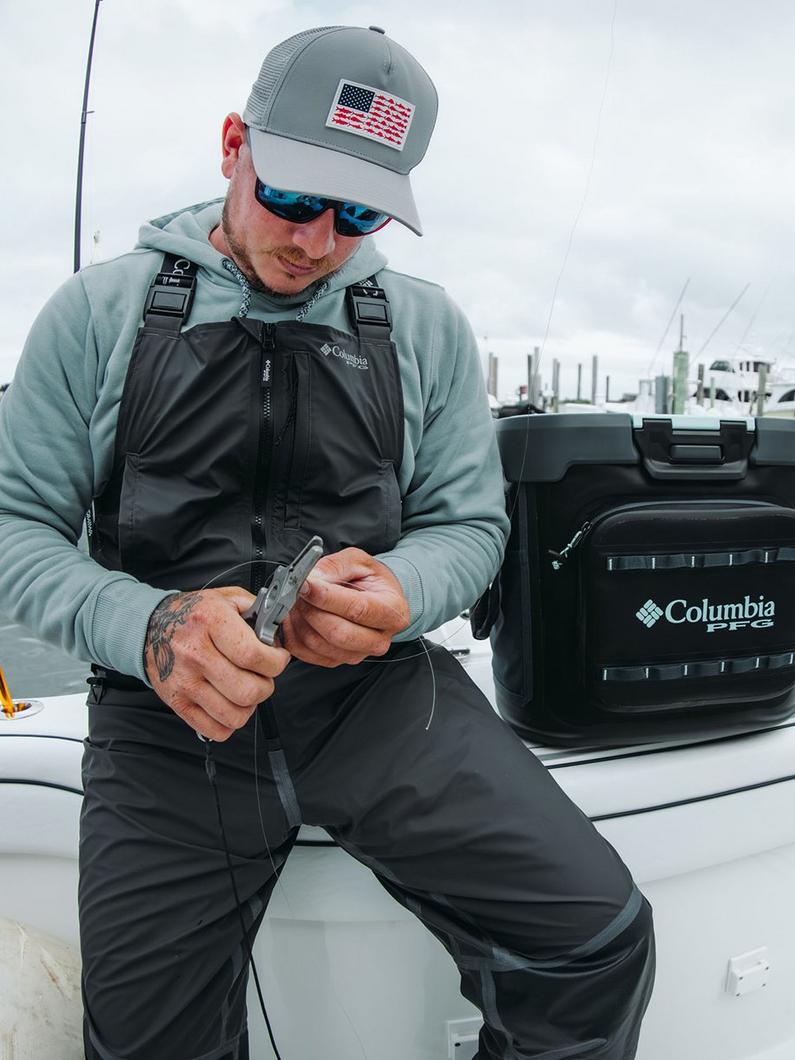 An angler working on tying a line.