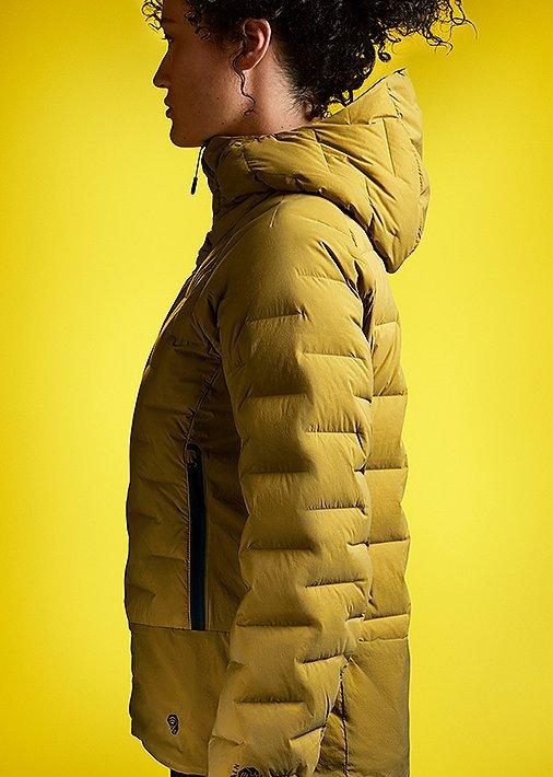 Side profile portrait in studio wearing the Super/DS Hoody with a tonal yellow background to match the jacket