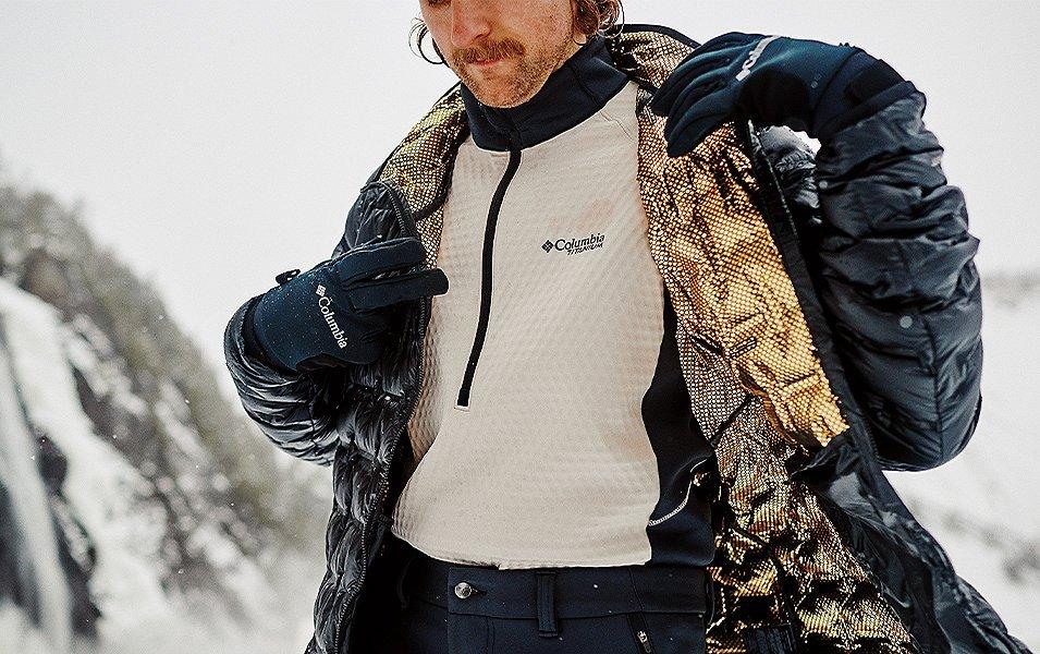 Man in the snow showing the Omni-Heat Infinity lining of his Columbia puffy jacket. 