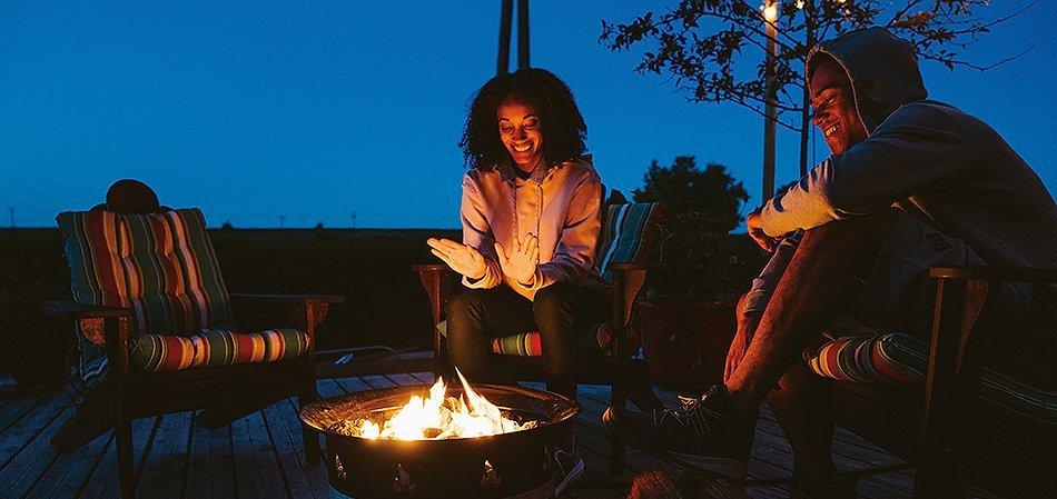 Two friends next to a bonfire.