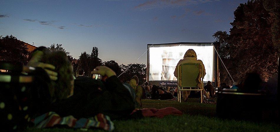 People watching an outdoor movie screen.