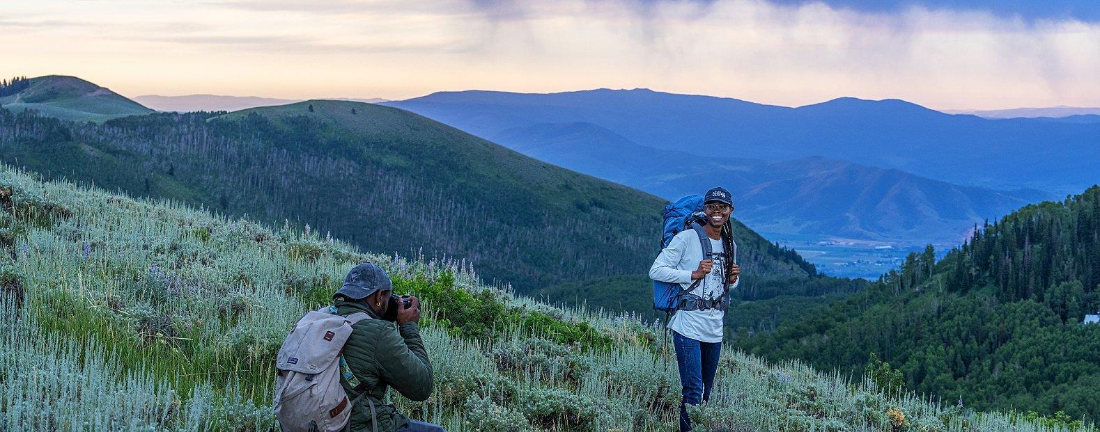 Open Aperture behind the scenes, a participant is taking photos of a hiker.