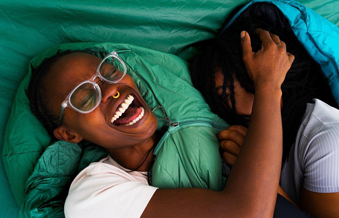 Smiling in sleeping bags in the tent.