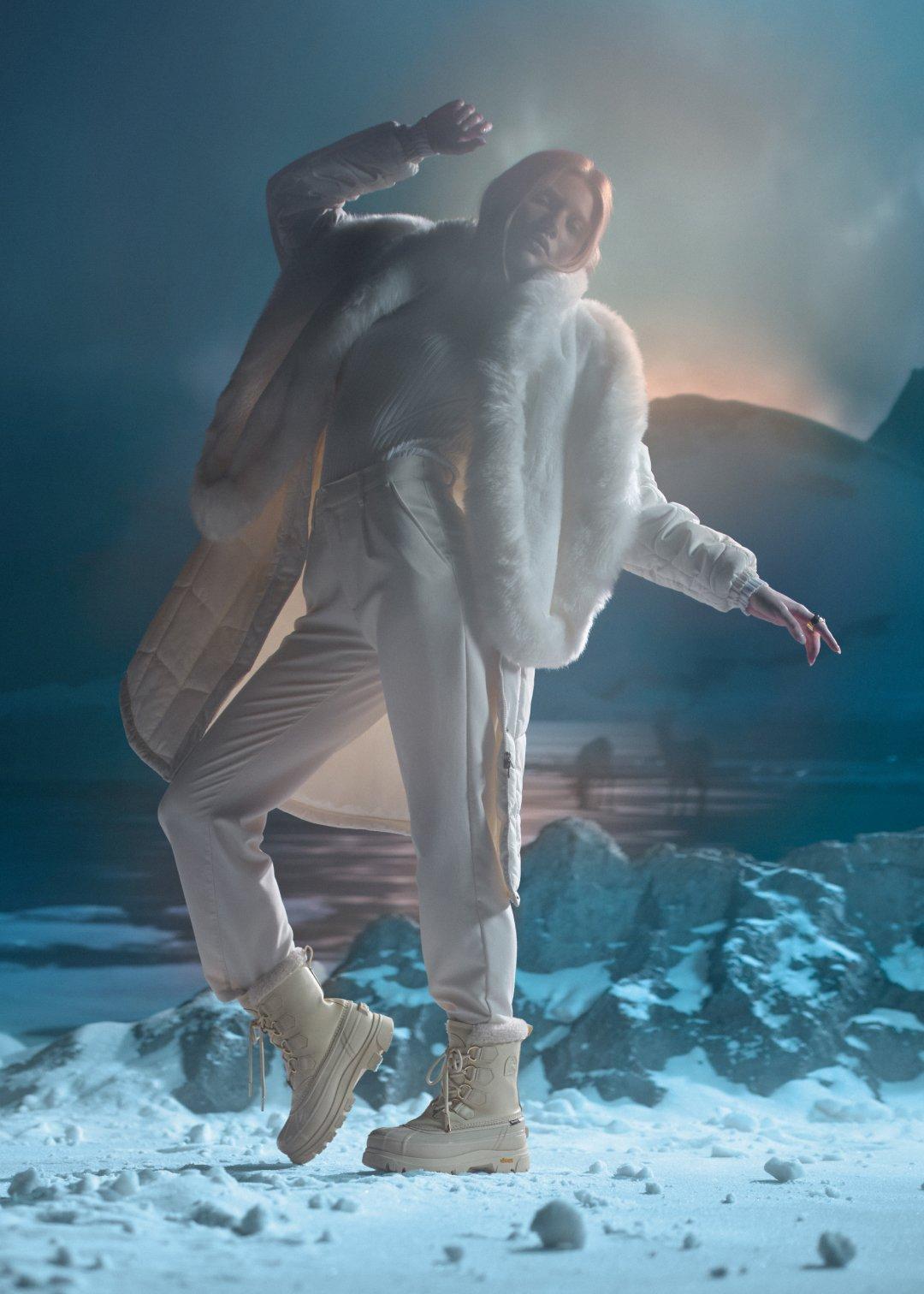 woman in an arctic background wearing white caribou horizon boots