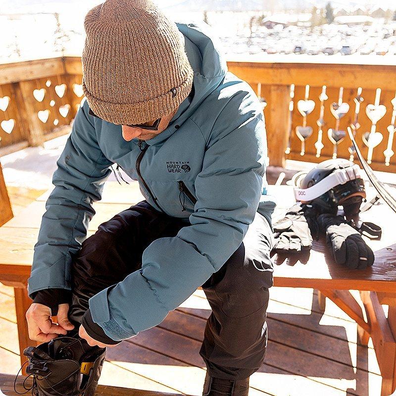 A skier adjusting his ski boots at the lodge