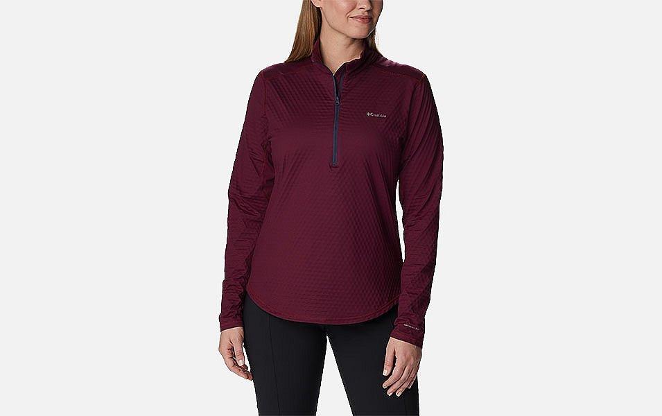 A product image of a woman wearing Columbia Sportswear’s Bliss Ascent Half Zip Shirt against a white background. 