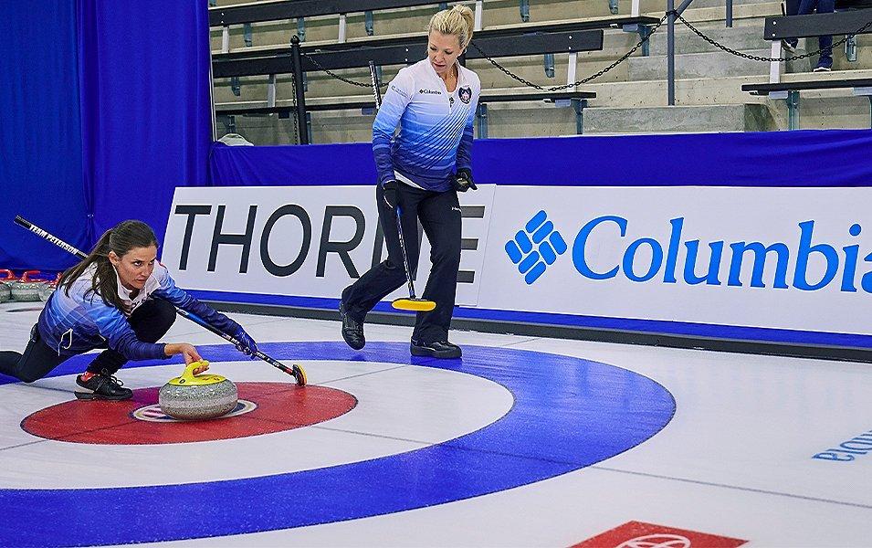 Two women curling. 