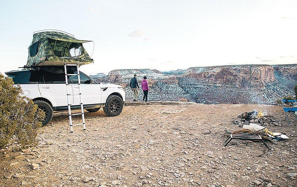 People at a campsite over looking a canyon vista. 