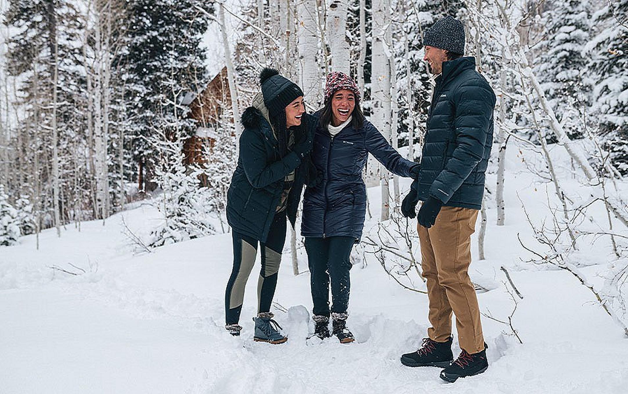 People on a snowy hike in a forest.