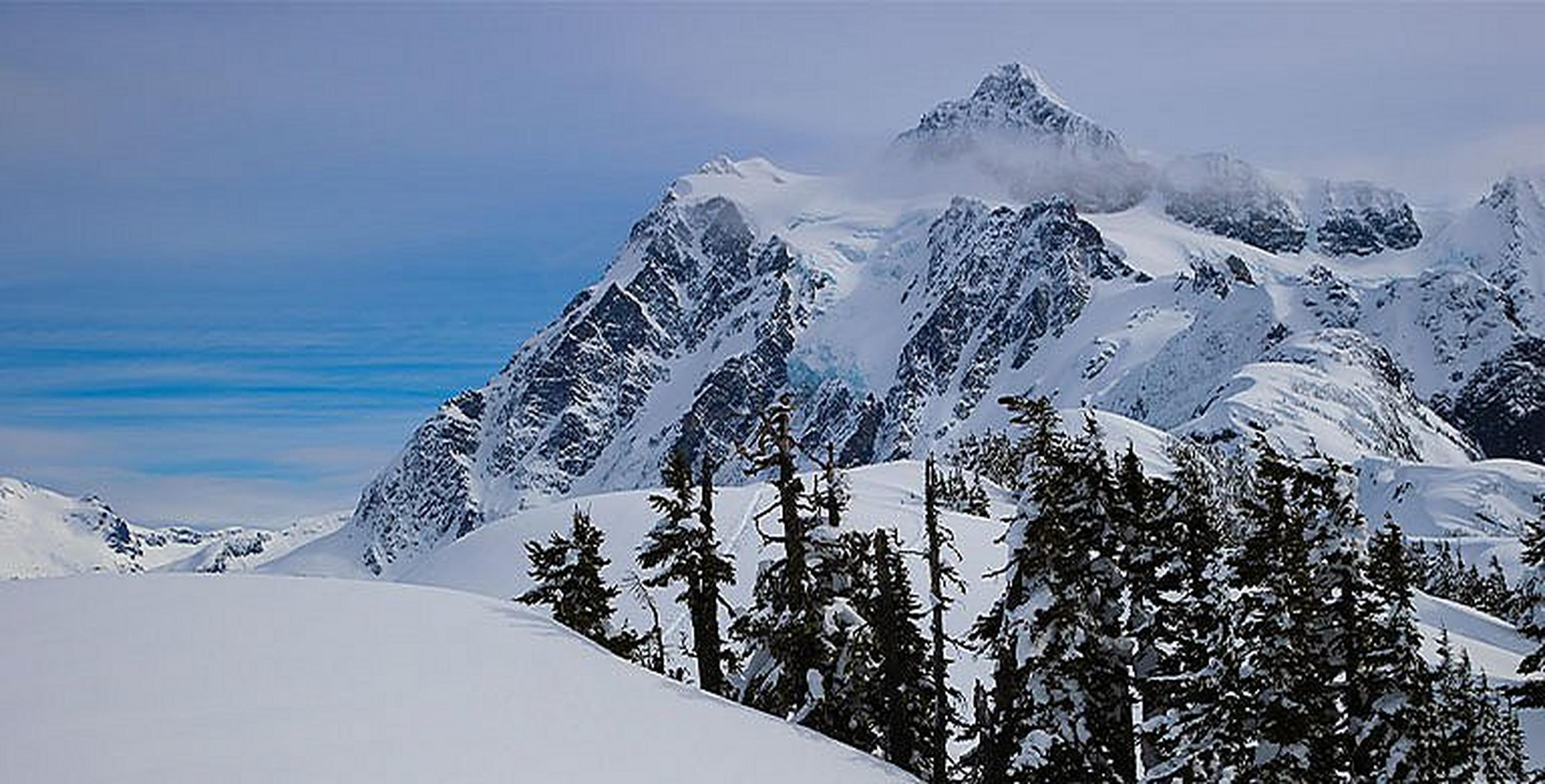 Person skiing down a snowy mountain on a sunny day.
