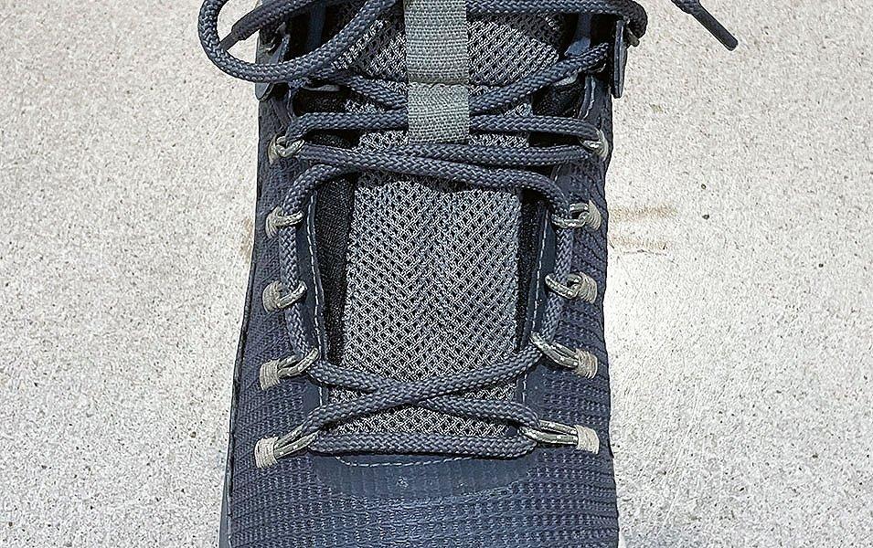  A close-up shot of a blueish-gray Columbia Sportswear hiking boot displaying window lacing.