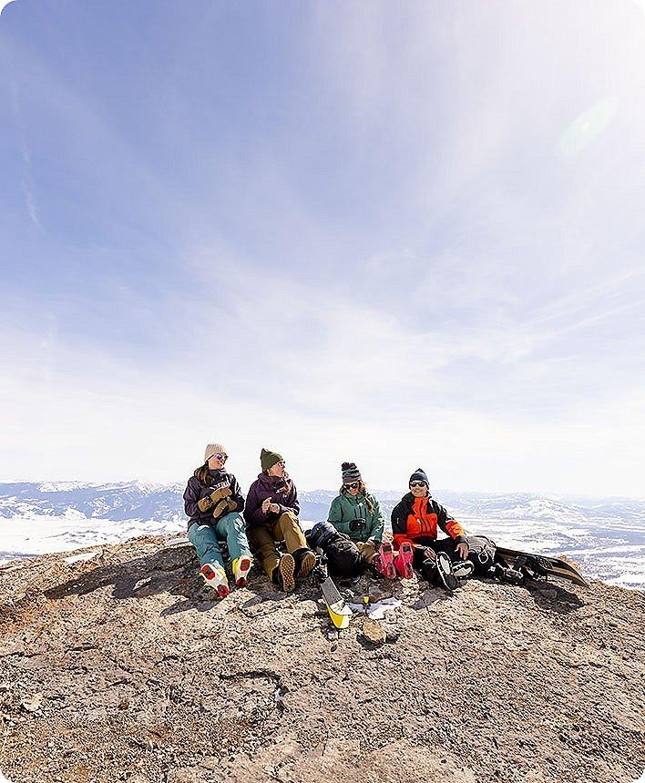 group of female skiiers taking a snack break on the slope