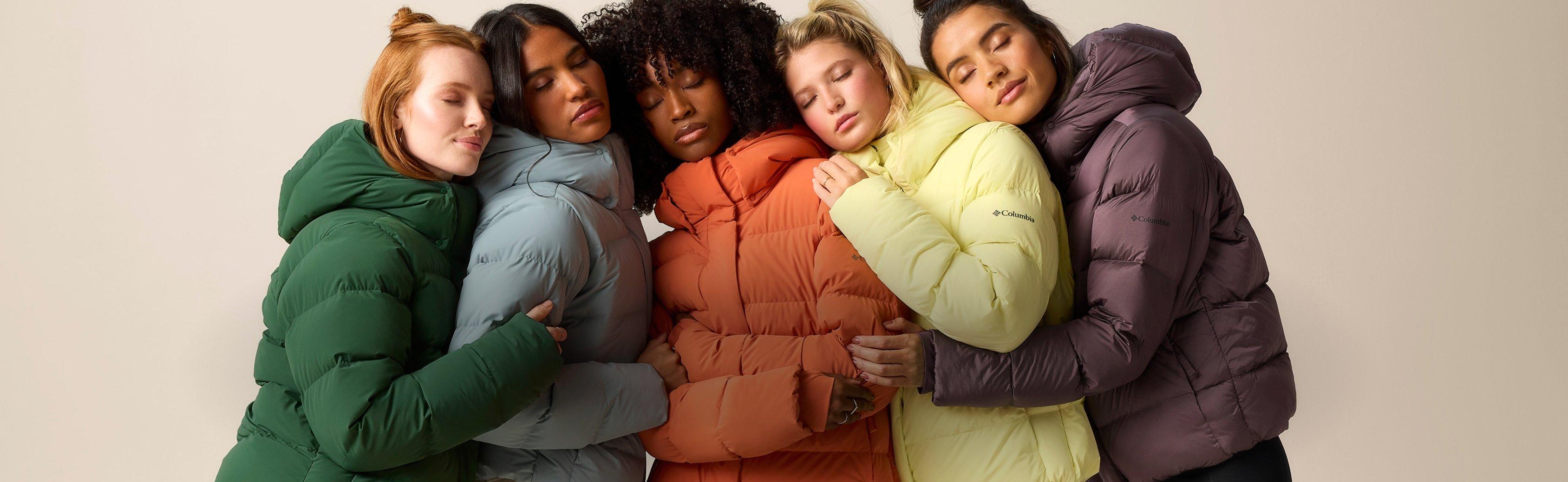 A group of gals huddled together in the Amaze Puff jacket in different colors.