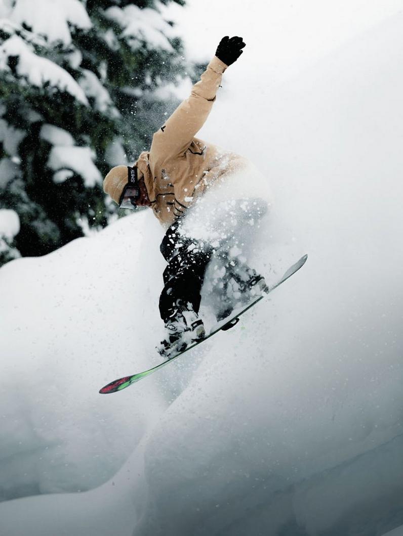 A pro snowboarder shredding down a hill.