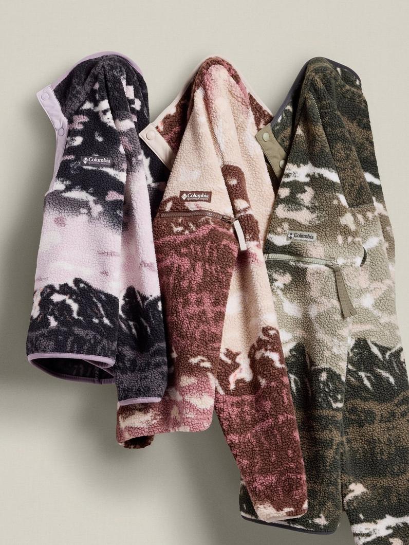 Three patterned fleece pullovers hanging on a hook.