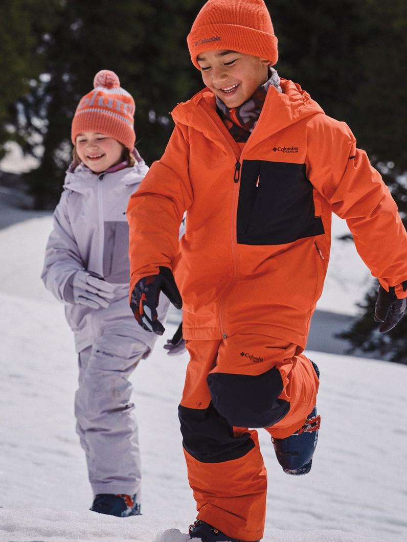 Two cute kids running in their snow gear.