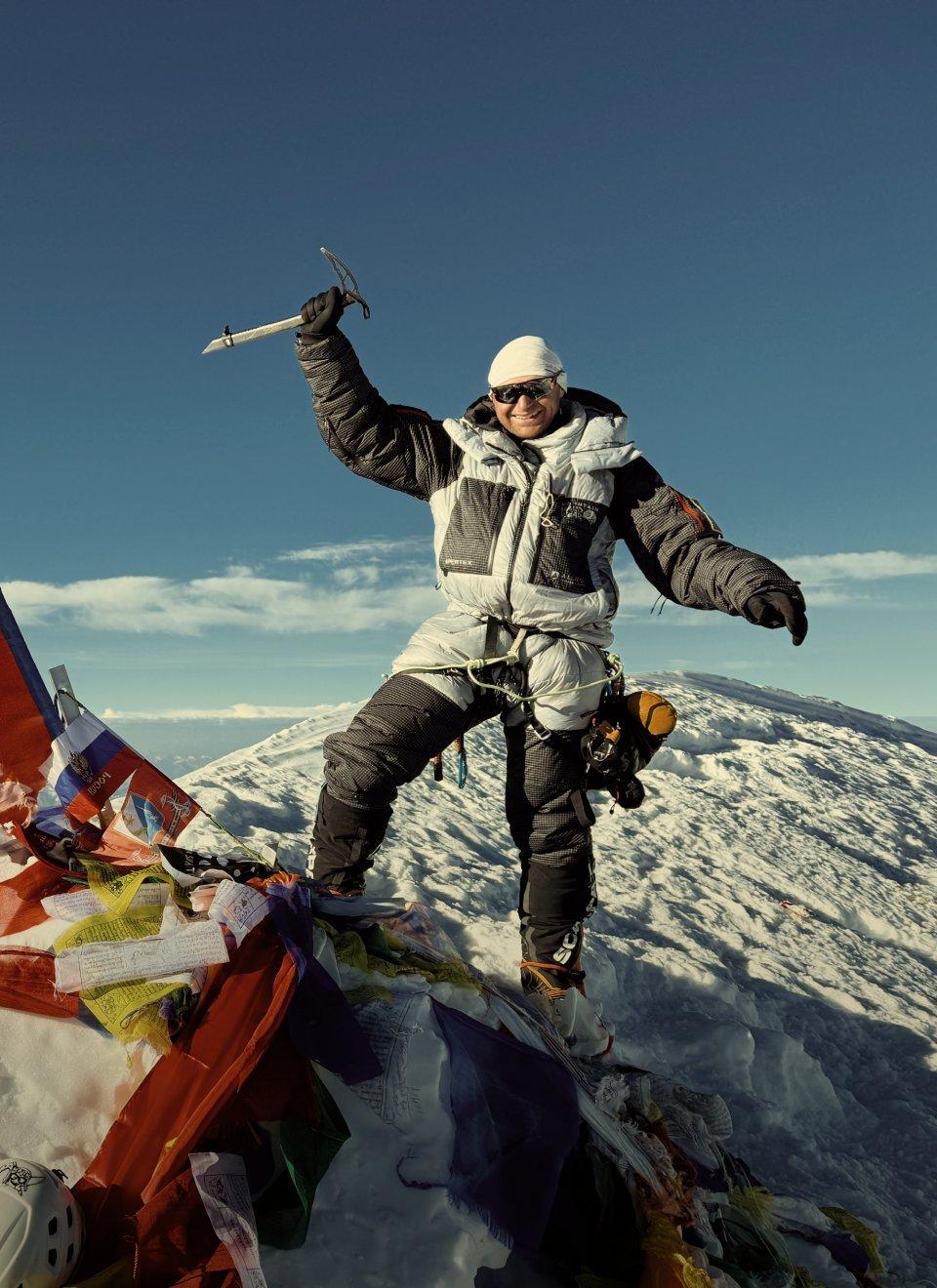 Benny Lieber summiting a mountain wearing Mountain Hardwear Men's Absolute Zero™ Suit.