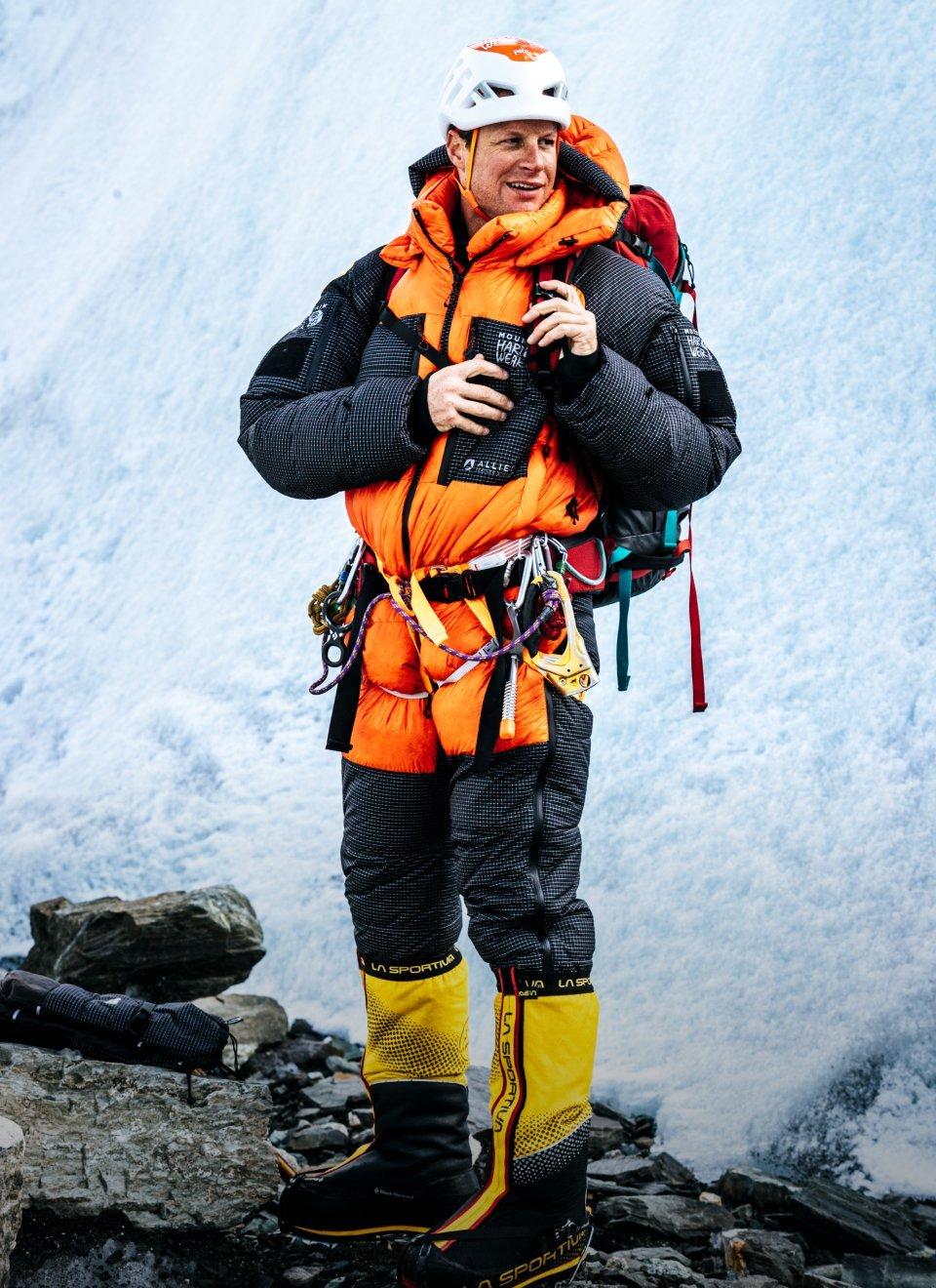 Garrett Madison summiting a mountain wearing Mountain Hardwear Men's Absolute Zero™ Suit.