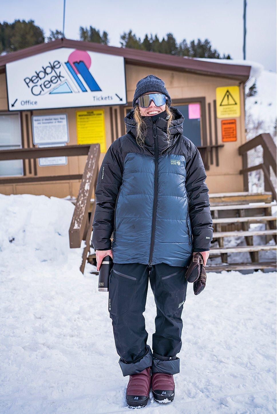 Erin Spong smiling at the camera in front of a snowy cabin.