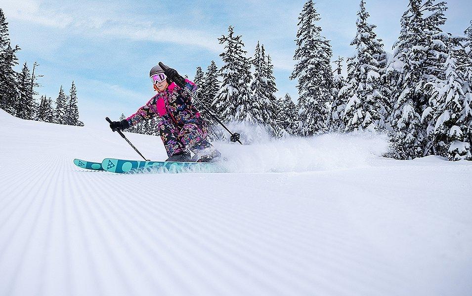 A skier comes down the mountain carving big turns. 
