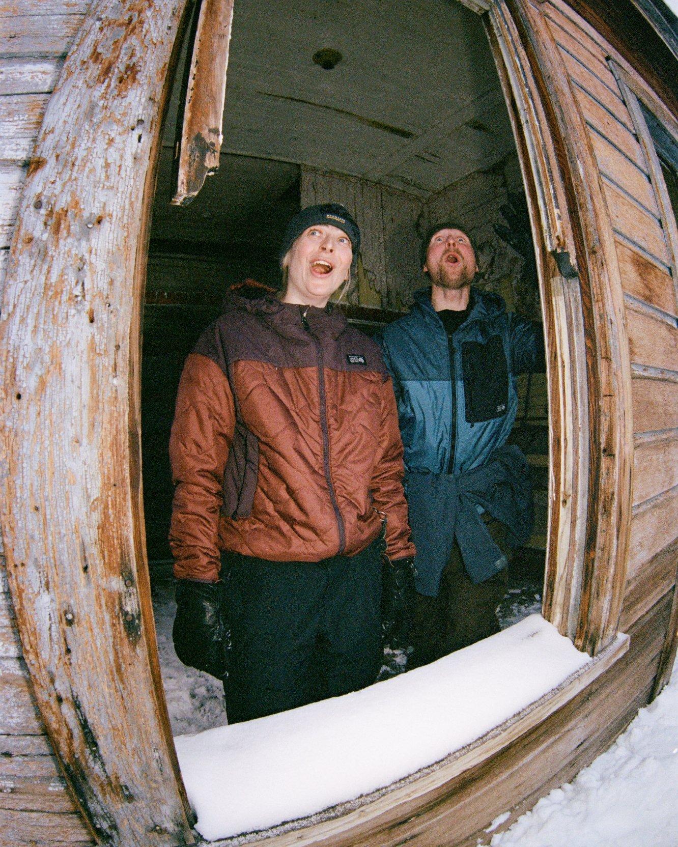 Stine Tønnessen and MHW athlete Jake Kuzyk taking in the snow view while wearing Apres Pro Insulated Hooded Jackets.