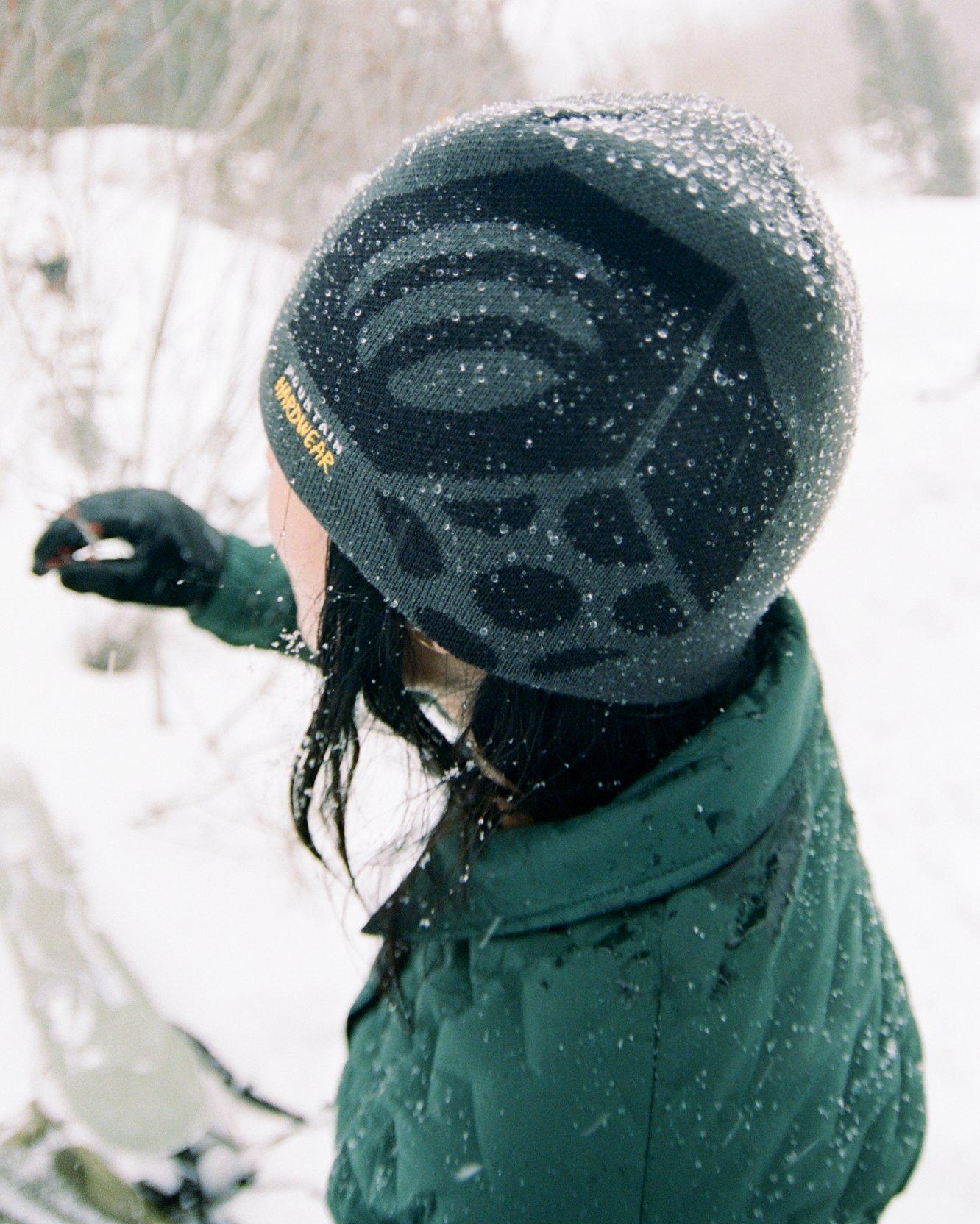 Close up of the Caelum Dome™ beanie and Women's Stretchdown Light Snap Jacket with a snowy backdrop.