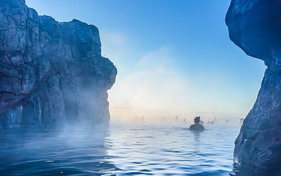 Steamy hot spring pool with rocky edges, in Iceland. 
